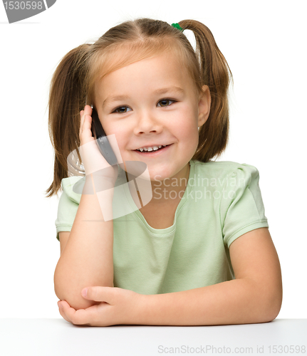 Image of Cute little girl is talking on cell phone