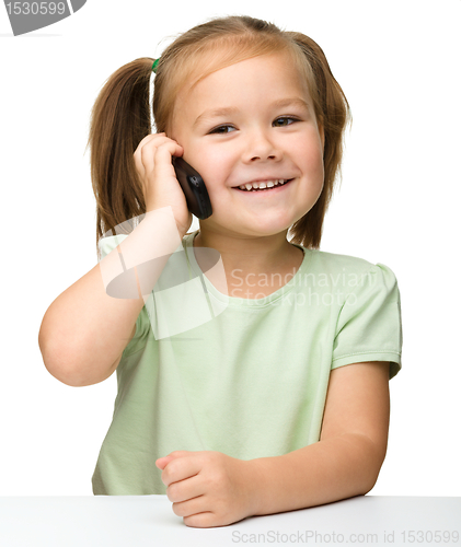 Image of Cute little girl is talking on cell phone