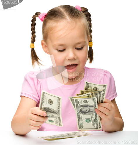 Image of Cute little girl is counting dollars