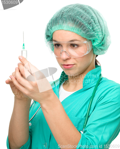 Image of Young nurse is preparing syringe for injection
