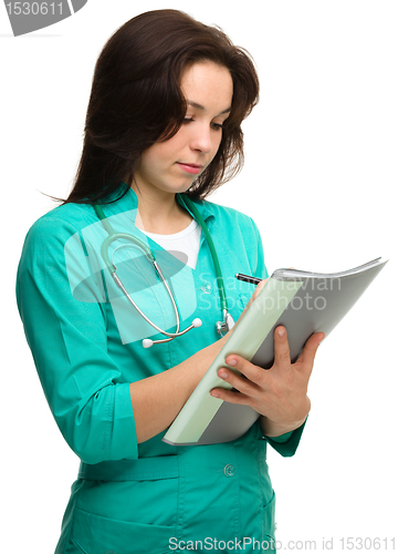 Image of Young attractive woman doctor is writing