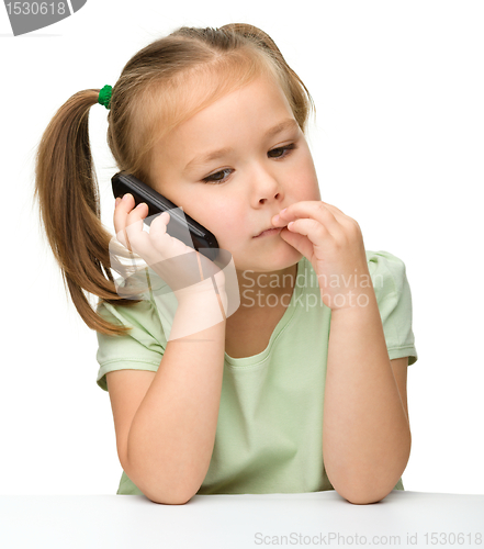 Image of Cute little girl is talking on a cell phone