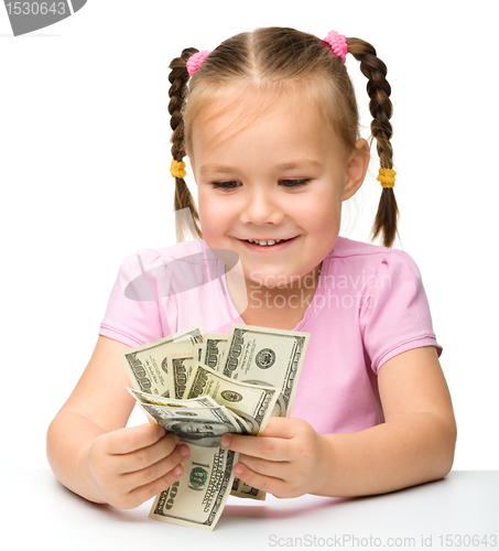 Image of Cute little girl is counting dollars