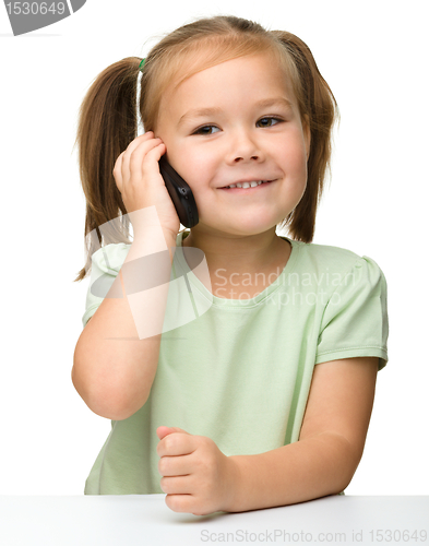 Image of Cute little girl is talking on cell phone