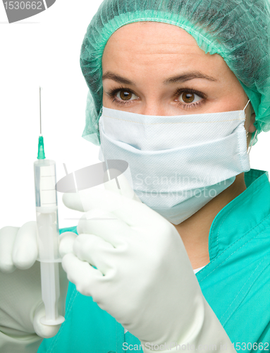 Image of Young nurse is preparing syringe for injection