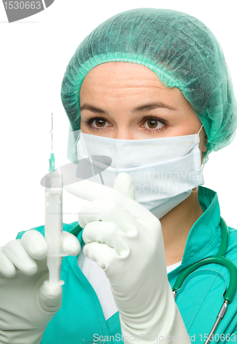 Image of Young nurse is preparing syringe for injection