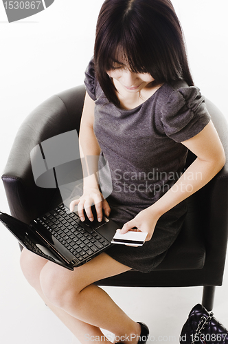 Image of Chinese woman shopping online with a credit card.