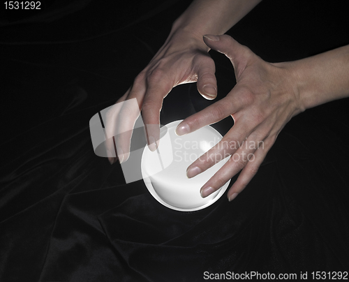 Image of crystal ball and hands around