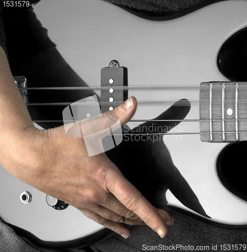 Image of hand on bass guitar