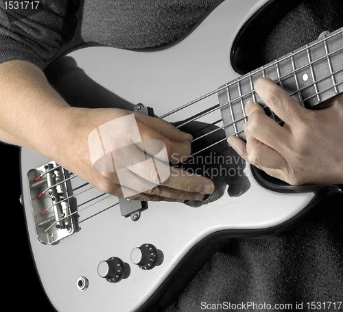 Image of hand on bass guitar