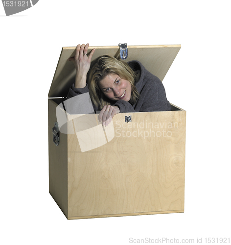 Image of girl sitting inside  a wooden box
