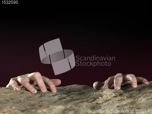 Image of clutchin hands on stone surface