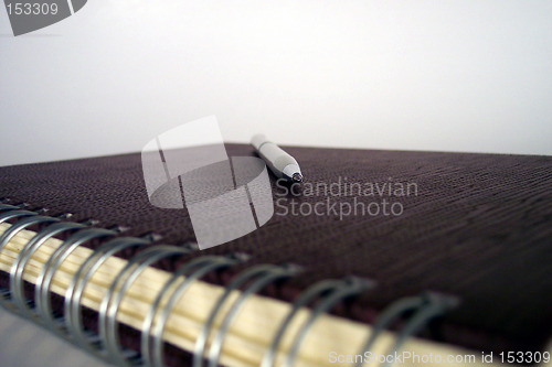 Image of pen on leather covered notebook