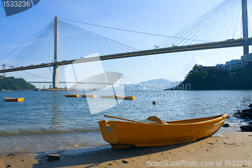 Image of boat on the beach under the bridge