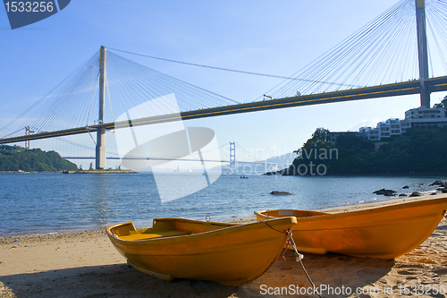 Image of boat on the beach under the bridge