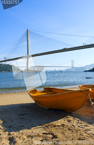 Image of boat on the beach under the bridge