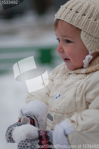 Image of Little girl plays with snowball
