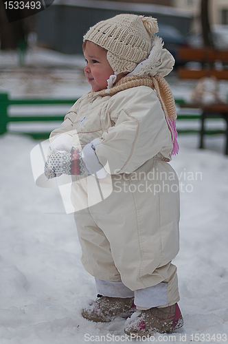 Image of Little girl plays with snowball