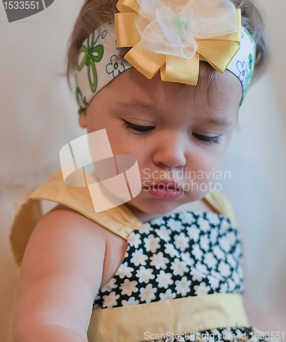 Image of Little thoughtful girl looks down