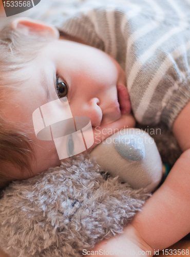 Image of Little girl hugs her teddy bear