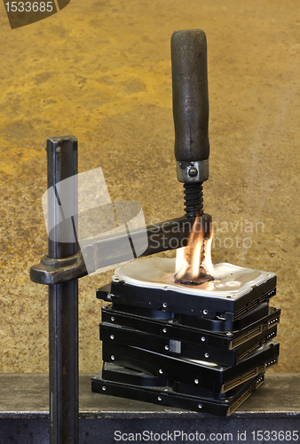 Image of clamp pressing on burning stack of hard drives