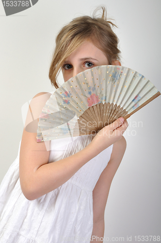 Image of beautiful girl hiding behind a fan