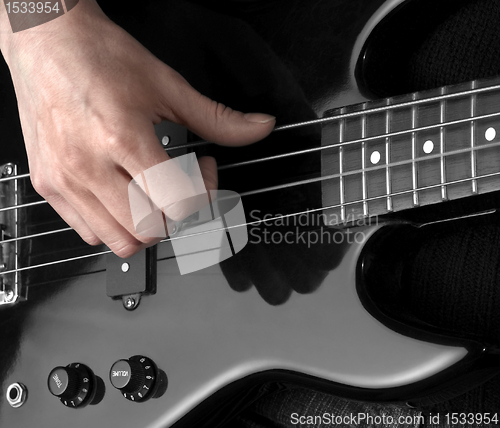 Image of hand on bass guitar