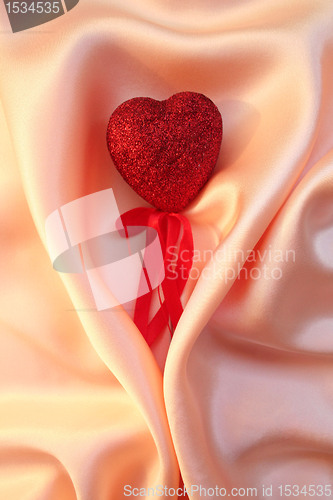 Image of Red heart on elegant pink silk for St Valentine's day background