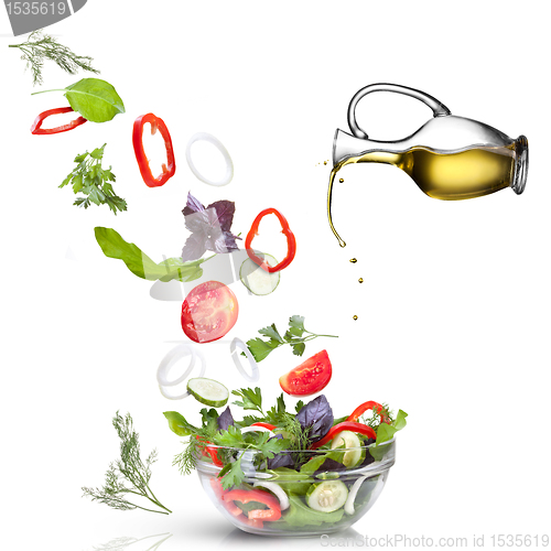 Image of Falling vegetables for salad and oil isolated on white 
