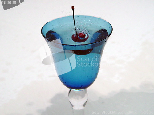 Image of Freshly dropped cherry in blue glass