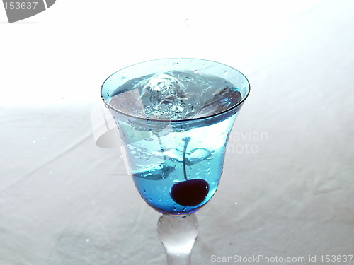 Image of Freshly dropped cherry in blue glass