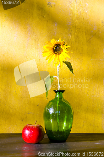 Image of Sunflower in glass vase and red apple still life 
