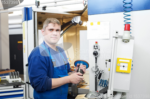 Image of worker operating CNC machine center