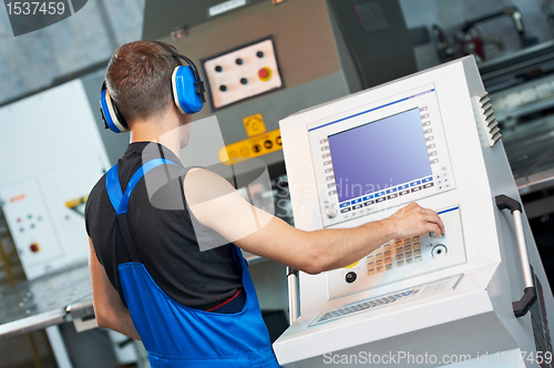 Image of worker operating cnc punch press