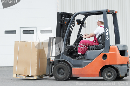 Image of warehouse worker driver in forklift