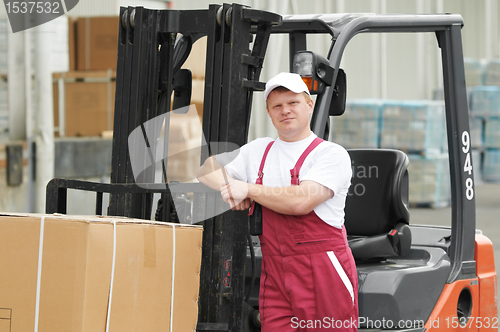 Image of warehouse worker in front of forklift