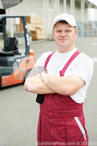 Image of warehouse worker in front of forklift
