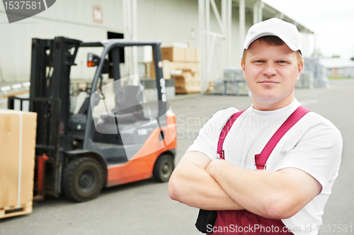 Image of warehouse worker in front of forklift