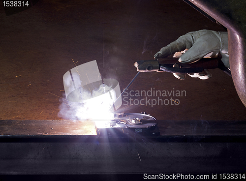 Image of welding on open hard disk drive in rusty background