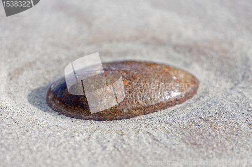 Image of single stone in sandy ground