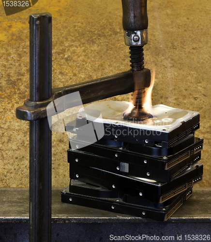 Image of pressed hard drives with clamp and fire