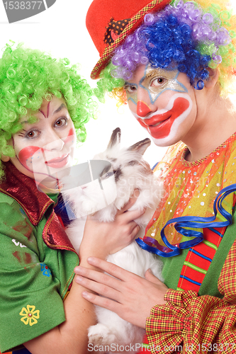 Image of Two smiling clown with a white rabbit