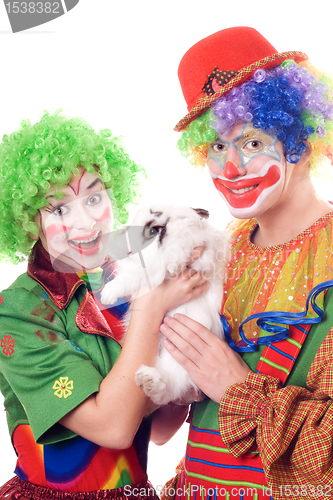 Image of Two joyful clown with a white rabbit