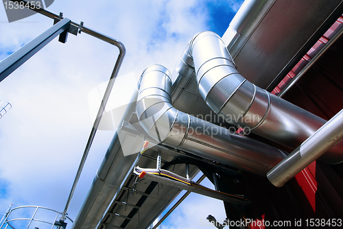 Image of Industrial zone, Steel pipelines and tanks against blue sky