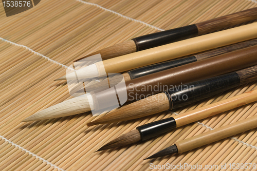 Image of chinese brushes on wooden mat detail