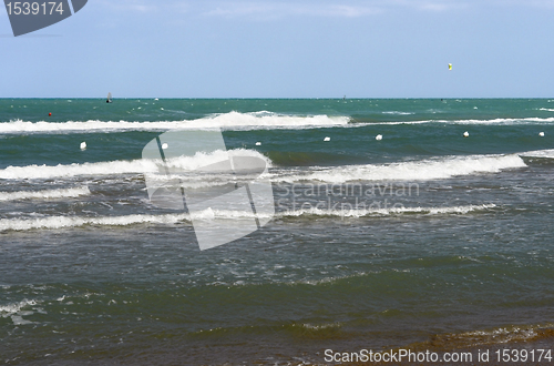 Image of surfers on green sea in Italy