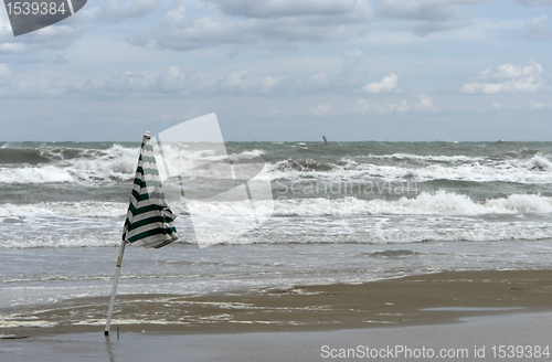 Image of beach scenery with sunshade and wavy sea