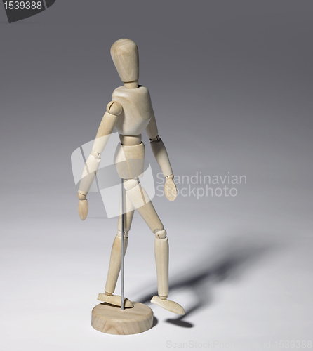Image of wooden doll in grey back