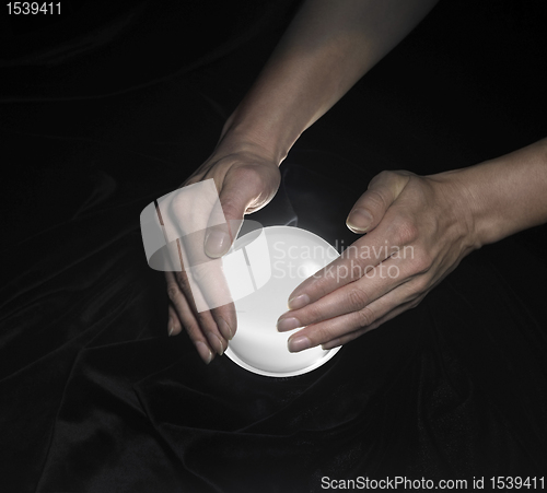 Image of crystal ball and hands around