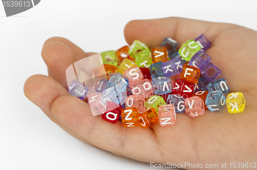 Image of Children hand holding cubes with letters